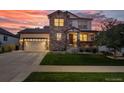 Charming two-story home with a well-manicured lawn, a stone facade, and a welcoming covered front porch at 12035 Fontberry St, Parker, CO 80134