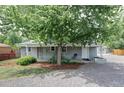 Charming gray home featuring a covered front porch and a mature shade tree at 2565 Pierce St, Lakewood, CO 80214