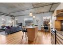 Modern kitchen and living space with hardwood floors, exposed ceilings, and natural light at 1499 Blake St # 3O, Denver, CO 80202