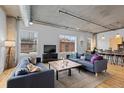 Comfortable living room featuring large windows, stylish sofas, and a textured area rug on hardwood floors at 1499 Blake St # 3O, Denver, CO 80202