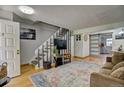Inviting living room featuring a staircase, stylish decor, and sliding barn doors at 1517 S Owens St # 5, Denver, CO 80232