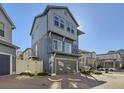 Modern two-story home featuring blue siding, a small balcony, and an attached garage at 5188 Andes Way, Denver, CO 80249