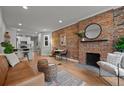 Cozy living room featuring a brick fireplace, hardwood floors, and stylish decor at 3003 California St, Denver, CO 80205