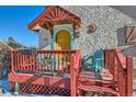 Inviting front porch with wooden deck and colorful chairs at 347 Buena Vista, Palmer Lake, CO 80133