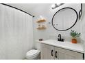 Modern bathroom featuring a round mirror, updated vanity, and stylish shower curtain at 9255 E Lehigh Ave # 208, Denver, CO 80237