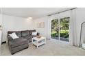 Living room with a grey couch, a white coffee table, and sliding glass doors leading to a balcony at 9255 E Lehigh Ave # 208, Denver, CO 80237