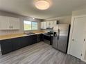 Updated kitchen featuring stainless steel appliances, light countertops, dark cabinets, and a window at 8491 W Star Cir, Littleton, CO 80128