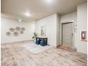 Bright condo hallway with modern decor, a console table, and blue ottomans creates a welcoming atmosphere at 15345 W 64Th Ln # 201, Arvada, CO 80007