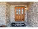 Elegant front door with glass panes and decorative details, complemented by brick siding and a welcoming mat at 1123 Oakhurst Dr, Broomfield, CO 80020