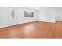Bright living room featuring wood floors, a bay window and a white front door at 5730 E 19Th Ave, Denver, CO 80220