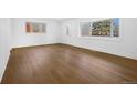 Bright living room featuring hardwood flooring and natural light from large windows at 5730 E 19Th Ave, Denver, CO 80220