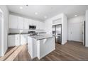 Bright kitchen featuring white cabinets, stainless steel appliances, and a granite-topped island at 3908 N Riviera Ct, Aurora, CO 80019
