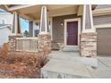 Close up of a cozy front porch featuring brick supports and a dark-colored front door at 5531 Fox Meadow Ave, Highlands Ranch, CO 80130