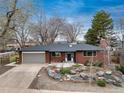 Charming red brick home featuring a well-manicured front yard and attached garage at 5743 Field St, Arvada, CO 80002