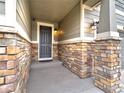 Stylish front entrance featuring a covered porch with stone columns and modern lighting at 10344 Vienna St, Parker, CO 80134