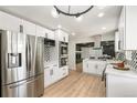 Modern kitchen boasting stainless steel appliances, white cabinets, and an open layout, perfect for entertaining at 423 Nile St, Aurora, CO 80010