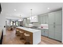 Elegant kitchen with a large island, seating for four, modern appliances, and light green cabinetry at 257 Jackson St, Denver, CO 80206
