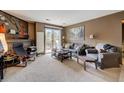 Cozy living room with light-colored carpet, brown walls, and sliding door to the outside balcony at 2900 Shadow Creek Dr # 201, Boulder, CO 80303