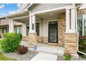 Inviting front porch features stone pillars, providing a welcoming entrance to the charming two-story home at 11761 Cord Grass Way, Parker, CO 80138