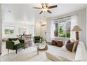 Bright living room featuring a large window, ceiling fan, hardwood floors, and comfortable seating arrangement at 11761 Cord Grass Way, Parker, CO 80138