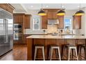 Well-equipped kitchen boasts stainless steel appliances, a center island, and sleek pendant lighting at 5470 Wabash St, Denver, CO 80238