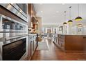 Modern kitchen features a suite of stainless steel appliances and a large island with barstool seating at 5470 Wabash St, Denver, CO 80238