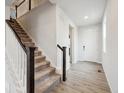 Inviting entryway with hardwood floors and a staircase, leading to the upper level of the home at 12353 E 101St Pl, Commerce City, CO 80022