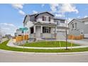 Beautiful two-story home with gray siding, complemented by a well-kept lawn and attached two car garage at 12353 E 101St Pl, Commerce City, CO 80022