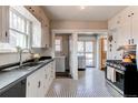 Bright kitchen with white cabinetry, stainless steel appliances, and a classic black and white tile floor at 342 9Th Ave, Longmont, CO 80501