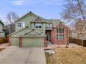 Charming two-story home with brick accents, a two-car garage, and manicured landscaping at 18338 E Powers Pl, Centennial, CO 80015