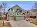 Charming two-story home with brick accents, a two-car garage, and manicured landscaping at 18338 E Powers Pl, Centennial, CO 80015