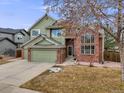 Charming two-story home with brick accents, a two-car garage, and manicured landscaping at 18338 E Powers Pl, Centennial, CO 80015