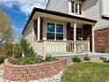 Charming front porch with brick accents and manicured landscaping at 18145 E Weaver Ave, Aurora, CO 80016