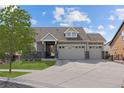 Charming home featuring a manicured lawn, a three-car garage, and a stone and siding facade under a sunny blue sky at 20162 E 53Rd Pl, Denver, CO 80249