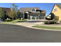 Traditional home featuring a manicured lawn, a three-car garage, and a stone and siding facade, for sale at 20162 E 53Rd Pl, Denver, CO 80249