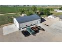 Exterior shot of a large shop with concrete parking pad and gravel drive at 6331 County Road 32, Platteville, CO 80651