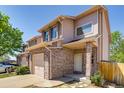 Brick facade townhome with attached garage and covered front porch at 2035 Overland Dr, Brighton, CO 80601
