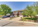 Exterior view of well-maintained townhomes with driveways and mature trees at 2035 Overland Dr, Brighton, CO 80601