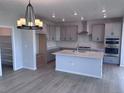 Open kitchen area with light gray cabinets, a center island with a sink, and stainless steel appliances at 4284 Ridgewalk Pt, Castle Rock, CO 80108