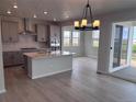 Spacious kitchen with gray cabinets, island, pendant lighting, stainless appliances, and a sliding glass door to the patio at 4284 Ridgewalk Pt, Castle Rock, CO 80108