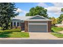 Single-Gathering home with an attached garage and manicured lawn in a serene suburban setting at 11 Canongate Ln, Highlands Ranch, CO 80130