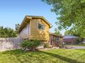 View of the home's exterior and manicured lawn, showcasing its curb appeal and well-maintained surroundings at 6664 Gray St, Arvada, CO 80003