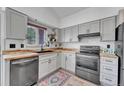 Well-lit kitchen featuring stainless steel appliances, light gray cabinetry, and butcher block countertops at 4726 S Taft St, Morrison, CO 80465