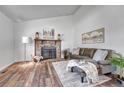 Bright living room with a stone fireplace, hard wood floors, and comfortable seating at 4726 S Taft St, Morrison, CO 80465