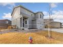 Charming two-story gray home with a three-car garage and a well-manicured lawn at 2405 Horse Shoe Cir, Fort Lupton, CO 80621