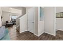 Bright hallway with wood floors, white trim, and a view into the living room at 2405 Horse Shoe Cir, Fort Lupton, CO 80621