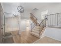 Inviting foyer with hardwood floors, coat closet, elegant staircase, and modern light fixture at 6527 S Ammons Ct, Littleton, CO 80123