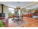 Open dining room with wood-burning stove, view of trees, and hardwood flooring at 167 Independence Cir, Breckenridge, CO 80424