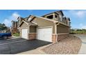 Close up view of garages in condo building with brick accents and a blue truck in the background at 3035 Blue Sky Cir # 10-207, Erie, CO 80516