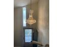 Elegant chandelier lighting up the entryway with view of door at 1473 S Monaco S Pkwy, Denver, CO 80224